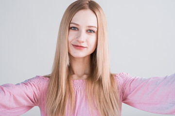 Fototapeta premium Portrait of young blonde woman with hug gesture in studio on white background