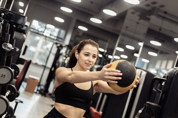 Fototapeta premium Sport woman exercising with medicine ball in hands in gym