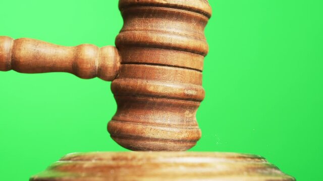 Gavel being struck to decide an auction or guilty verdict in court. Green Screen. Medium and wide shot with Alpha channel Black and white included.