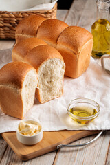 Side view on loafs of fresh baked shaped wheat bread with butter and coffee