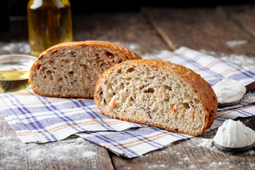 Side view on cut loaf of rustic bread with filling on the wooden table