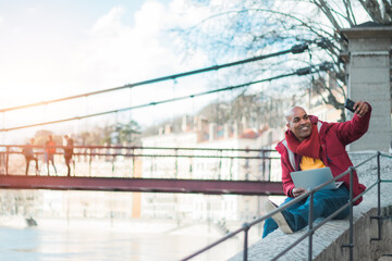 black man in the city of Lyon, France. On the street using his smart phone