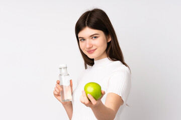 Young Ukrainian teenager girl over isolated white background with an apple and with a bottle of water
