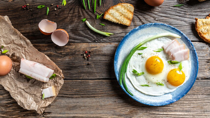 Traditional Ukrainian or belorussian food. Breakfast, lunch bacon, lard fried eggs and toast on old wooden table. banner, catering menu recipe place for text, top view