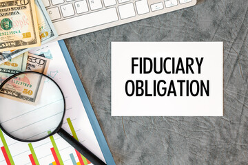 Fiduciary Obligation is written in a document on the office desk, money, diagram and keyboard