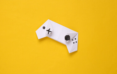 Origami gamepad on yellow background.