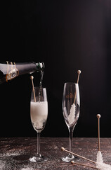 szampanówka z ozdobną pałeczką oraz szampanem musujacym podczas nalewania.  © Svitlana