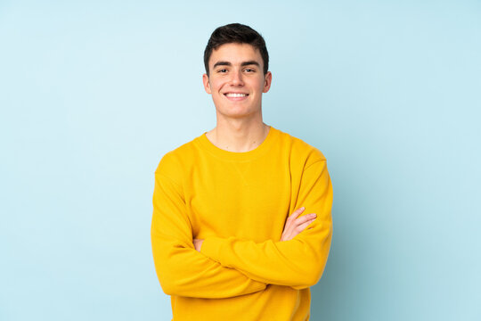 Teenager caucasian handsome man isolated on purple background keeping the arms crossed in frontal position