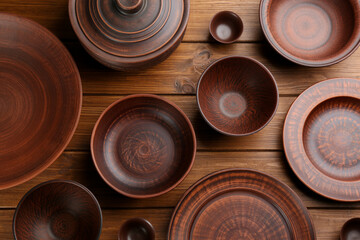 Set of clay dishes on wooden table, flat lay