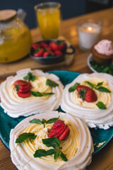 Obraz na płótnie Canvas Meringue and whipped cream dessert layered with seasonal strawberry.