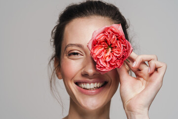 Joyful half-naked woman making fun with flower