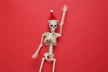 Skeleton with santa hat on red background