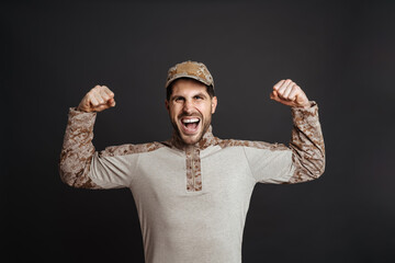 Excited masculine military man screaming and showing his biceps