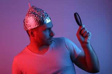 Bearded Man in Foil Hat Holds Magnifier in Red Blue Neon Light