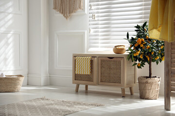 Wooden commode near window in room. Interior design