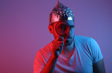 Bearded Man in Foil Hat Holds Magnifier in Red Blue Neon Light