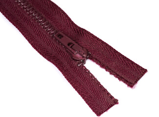 Slider of red purple metal zipper close-up, selective focus