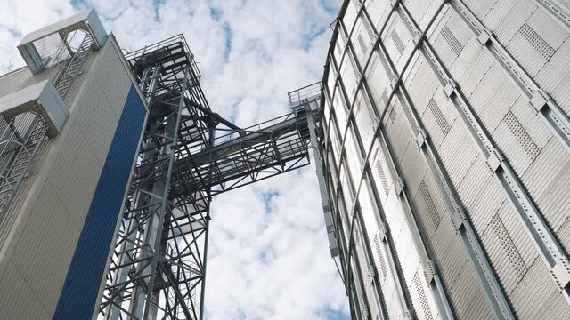 Steel Grain Elevator. Modern Agricultural Plant On Sky Background. Large Silver Containers For Drying Grains. Metal Construction Of A Large Architecture.