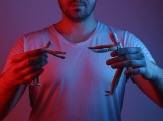 Male puppeteer shares puppets in red blue neon light