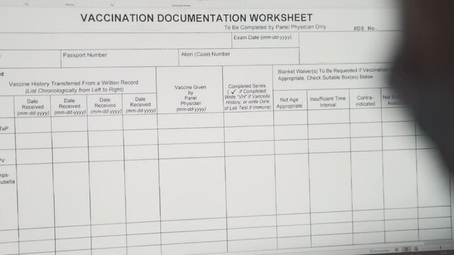 Close up shot of the computer monitor in the hospital with vaccination documentation worksheet. Travelling during coronavirus lockdown. Modern medicine solutions in pandemic