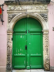 Bright green wooden doors with beautiful stone portal