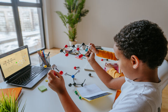 Boy watching online lesson chemistry science holding molecular model