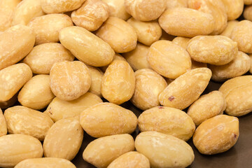 Fototapeta na wymiar Roasted salted peanuts close-up in selective focus