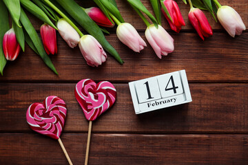 Valentine's Day concept. Wooden calendar 14 February, beautiful tulips flowers and heart shaped...