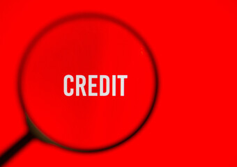 Word credit on red screen through magnifying glass.