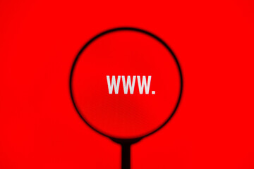 Website address www. on red screen through magnifying glass.