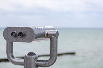 Steel tourist binoculars on the observation deck for viewing the endless sea