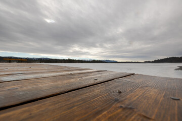 Wooden nose-piece on frozen lake in Upper Bavaria with Alps in background in winter with snow