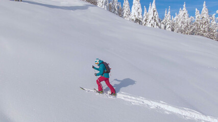 DRONE: Scenic wintry landscape surrounds a woman on a ski touring adventure