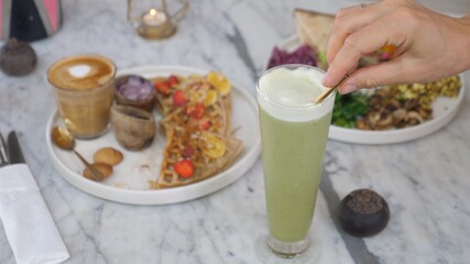 Clean eating concept. Vegan brunch of waffles, omelette, vegetables, plant based latte and matcha ice latte