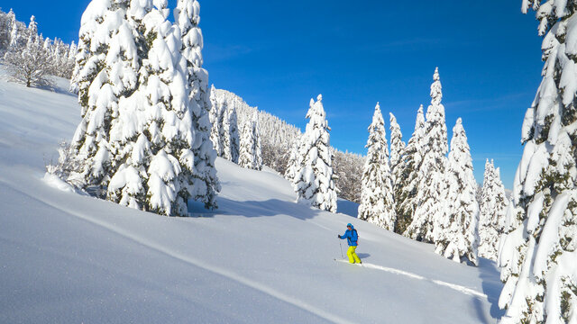 DRONE: Fit Caucasian man crosses the wintry landscape during a ski touring trip.