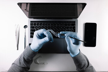 View from above of doctor's hands working with dental aligners