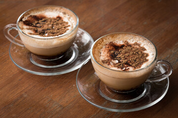 Two Glass Cups of Cappuccino Coffee on Wooden Table