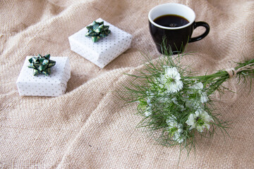緑のリボンの贈り物とニゲラの花束とコーヒー