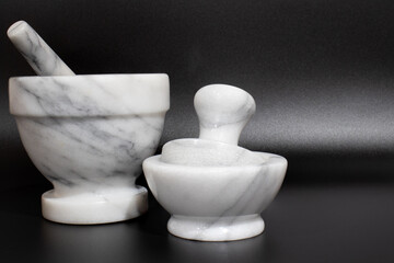 Large and small pestle against a black background