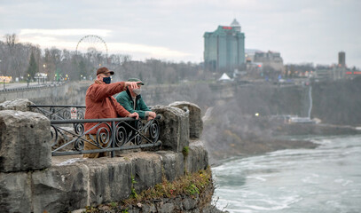 Senior Caucasian gay married couple enjoy their visit to Niagara Falls, Ontario, Canada.