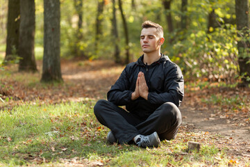 Obraz premium Sport man meditates in the lotus position in the autumn forest.