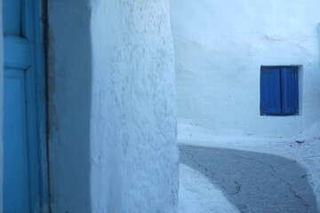 narrow street typical of greece with blue window