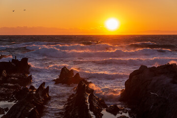 荒崎海岸から春一番の荒海に沈む夕日