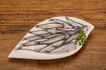 Anchovies in the bowl served basil leaves
