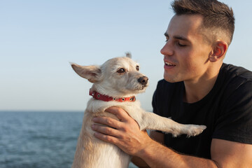 Cute dog with owner man spend time together on the coast