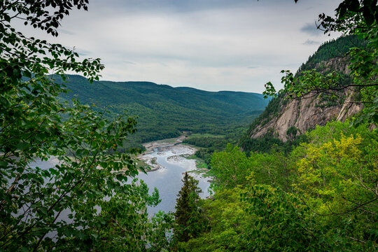 Huge cliffs flowing down into the bay and bushes in Fjords du Saguenay, Quebec Province, Canada, from Notre-Dame-du-Saguenay track during a cloudy day © Benoit