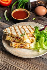 quesadilla Traditional Mexican tortillas with scramble eggs, vegetables, ham and cheese. vertical image
