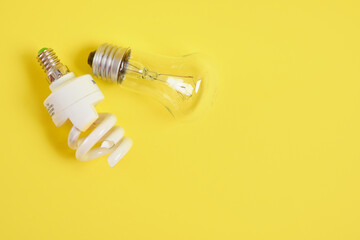 broken screw and incandescent light bulbs on trendy yellow background