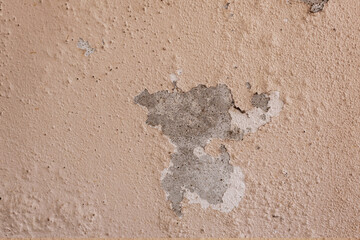 The exterior of the building has an old cement wall with paint cracks.
