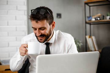 Young businessman working on laptop at office. Businessman sitting at office desk working on new project.